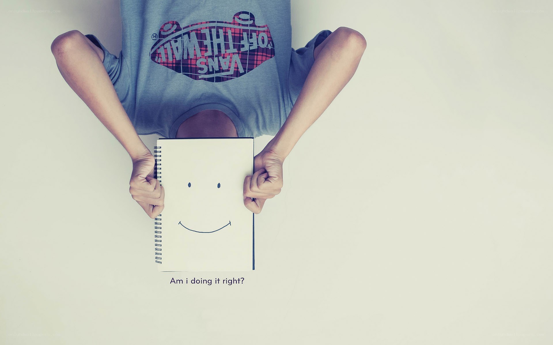 person holding a smiley face notebook