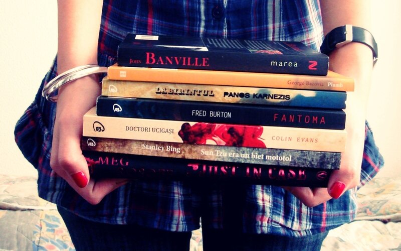 person holding a stack of books