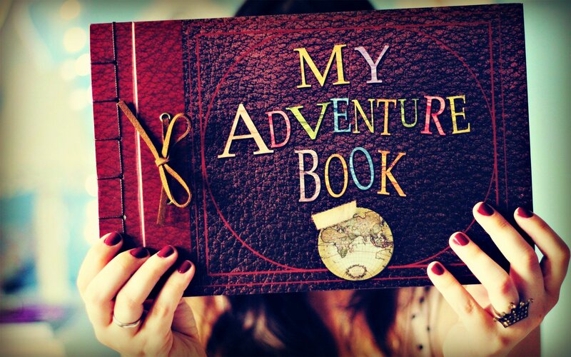 Person Holding Adventure Book — Red