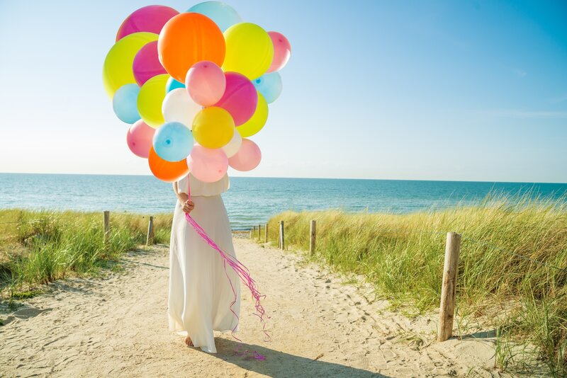 Person Holding Balloons — White