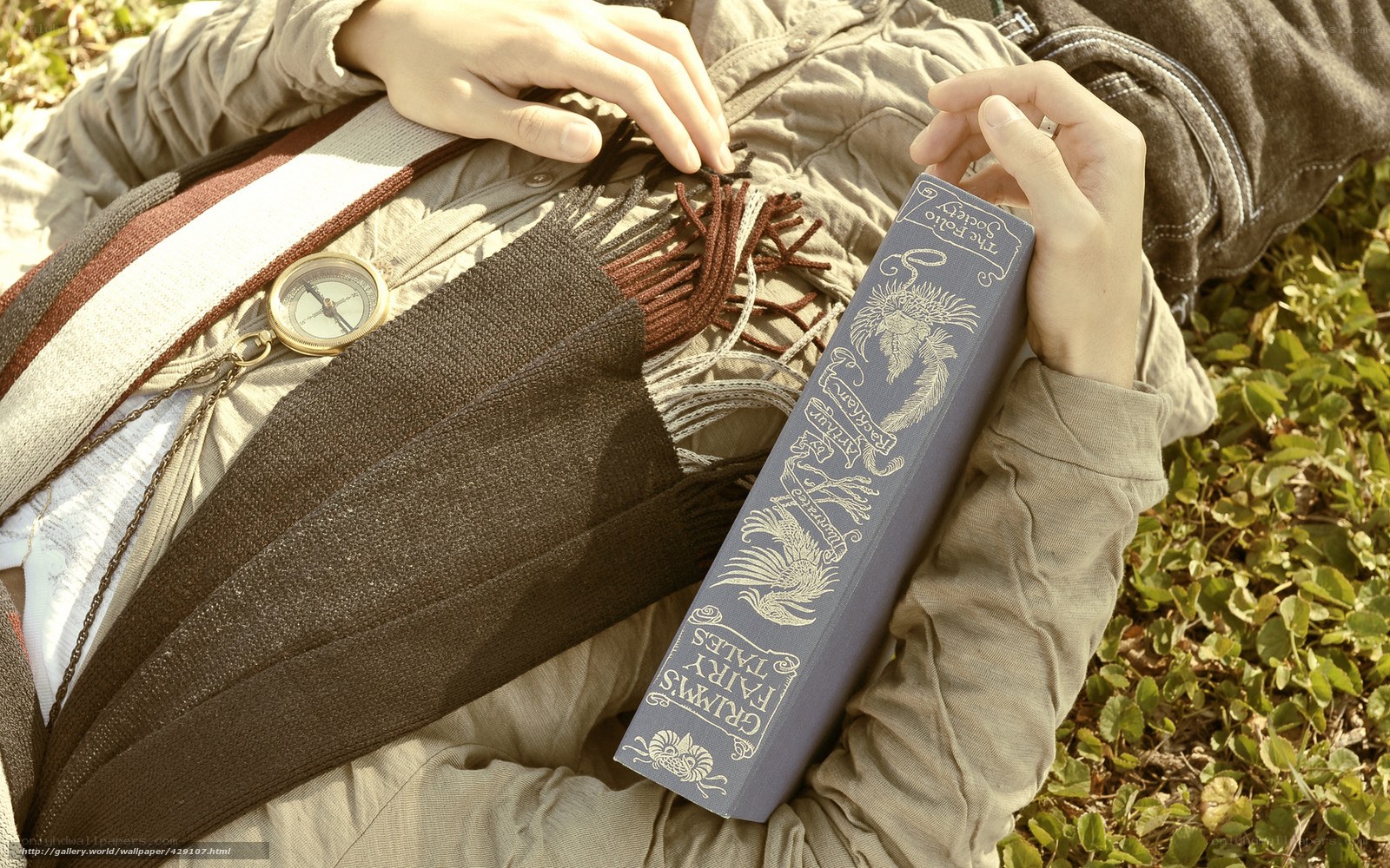 person holding book and compass