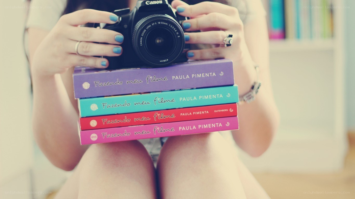 person holding camera and books