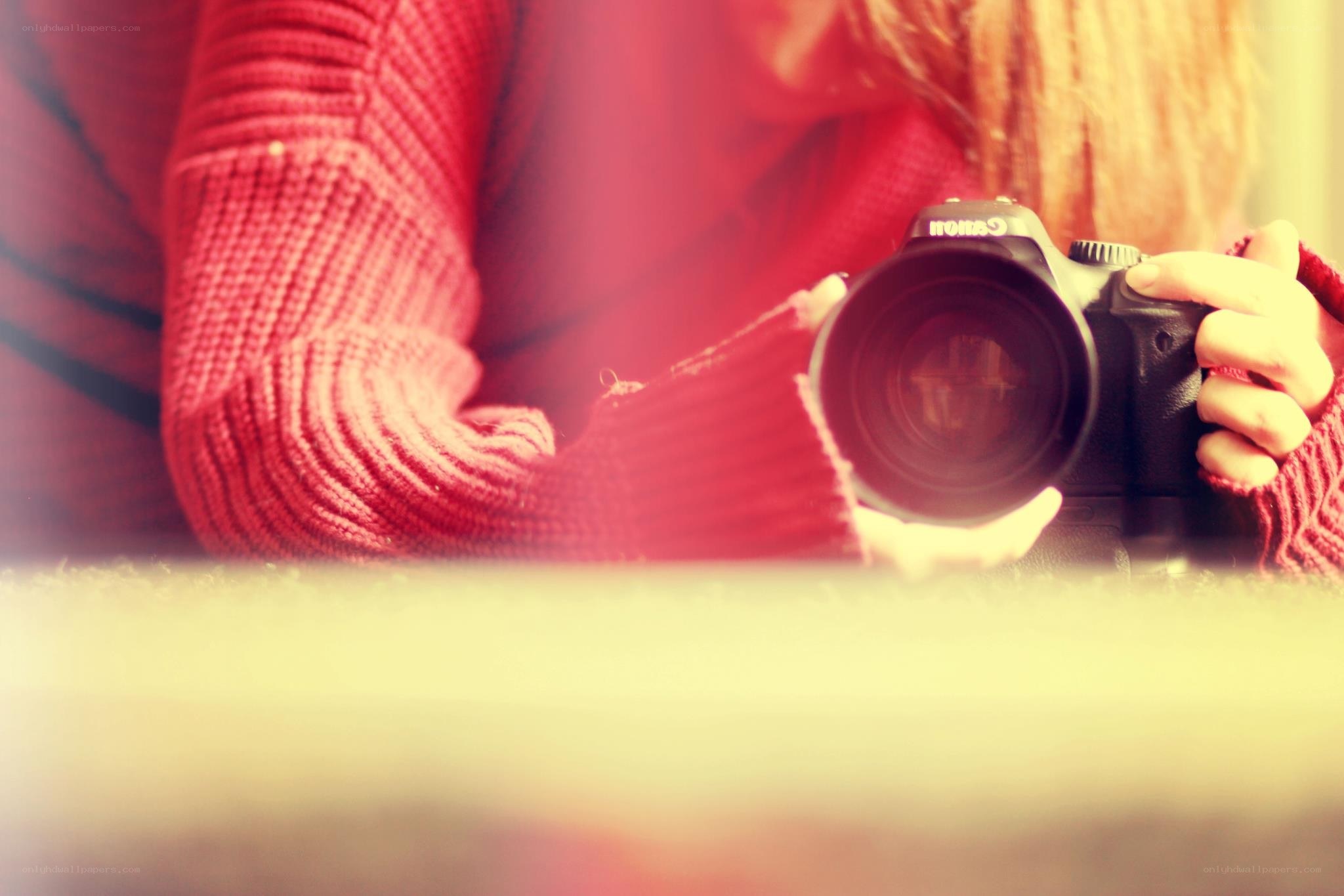 person holding camera in red sweater