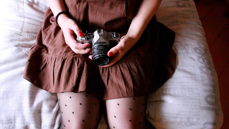 person holding camera on bed