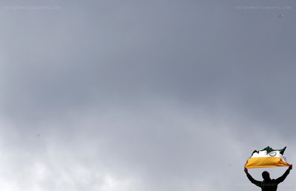 Person holding flag against sky