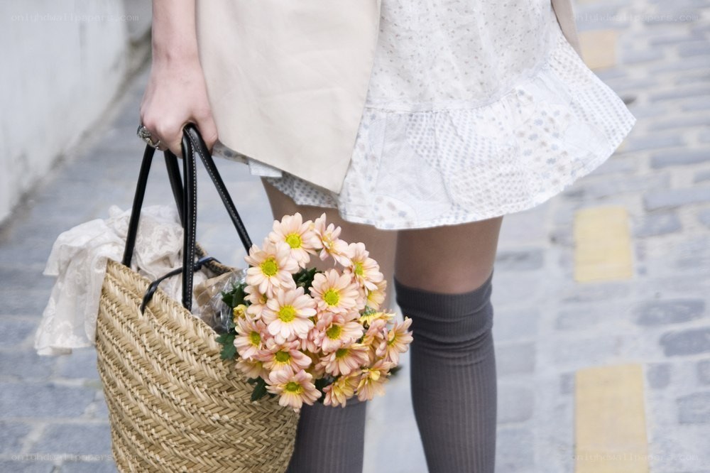 person holding flowers and bag