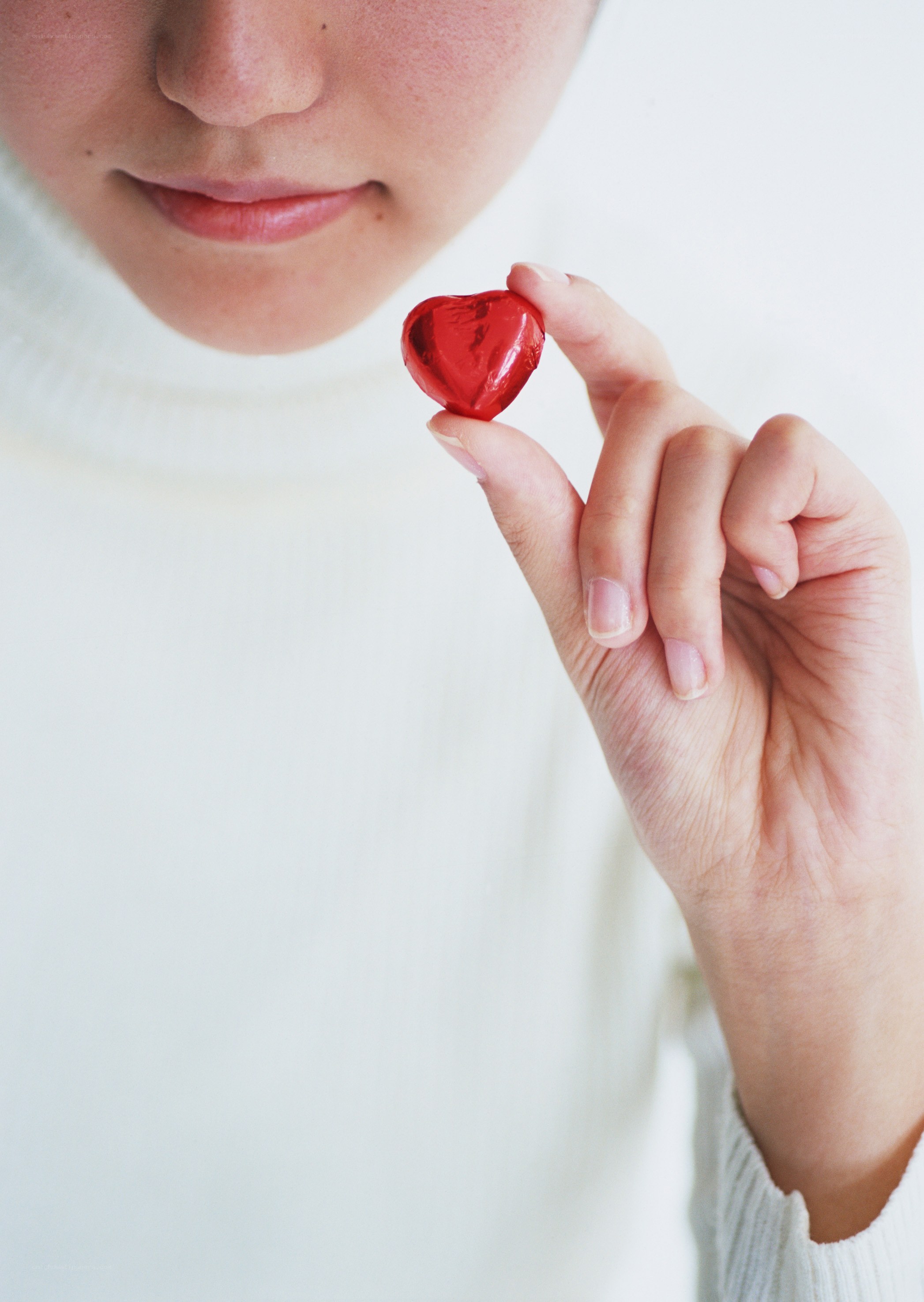 person holding heart-shaped candy