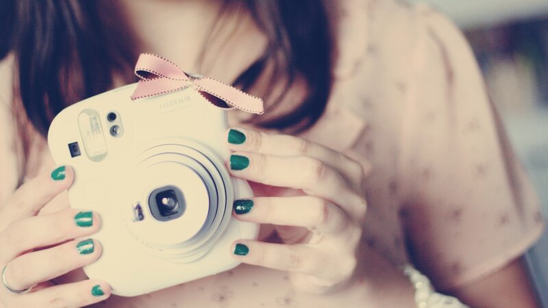 person holding instant camera