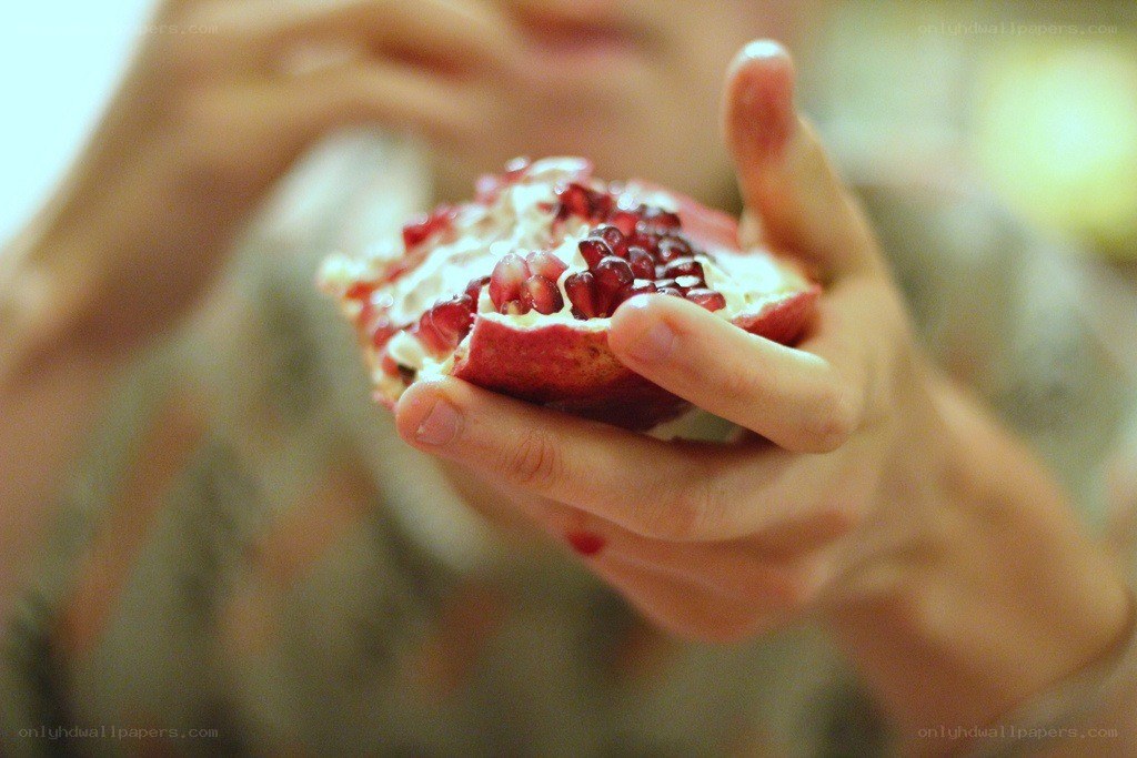person holding pomegranate