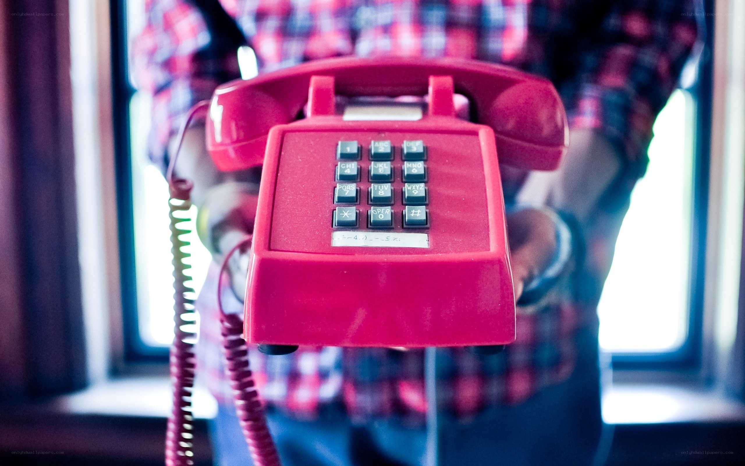 person holding red telephone