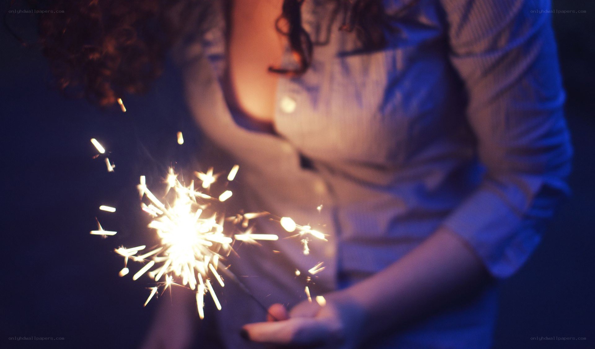 person holding sparkler at night