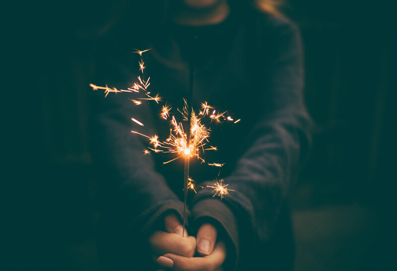 person holding sparkler at night