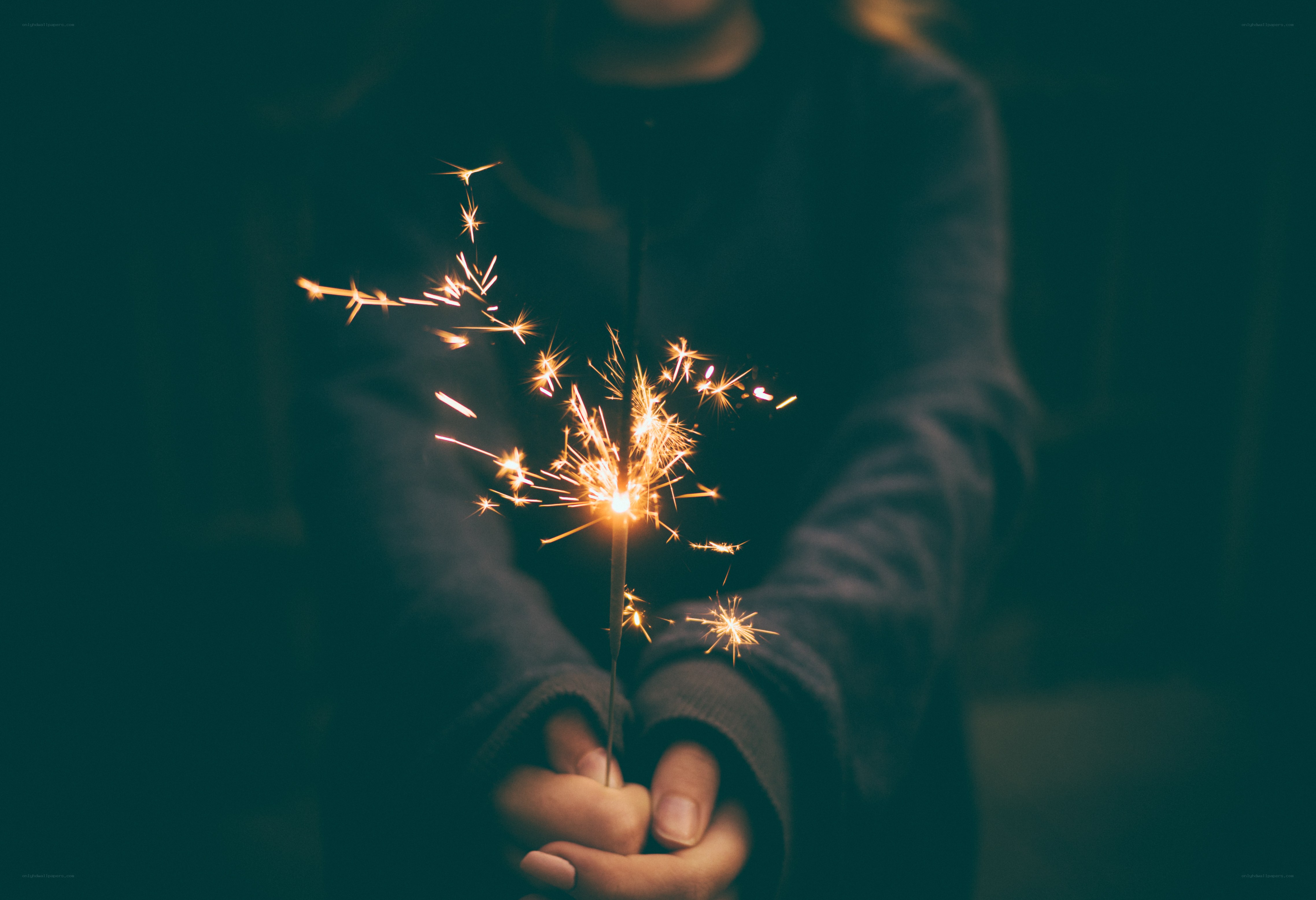 person holding sparkler at night