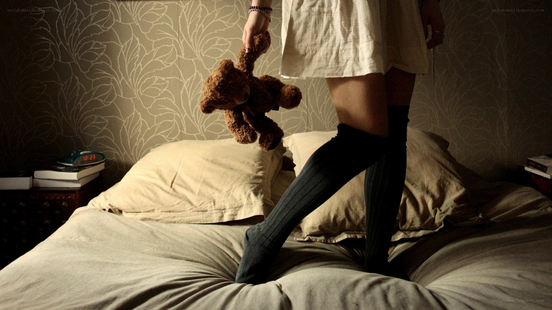 person holding teddy bear on bed