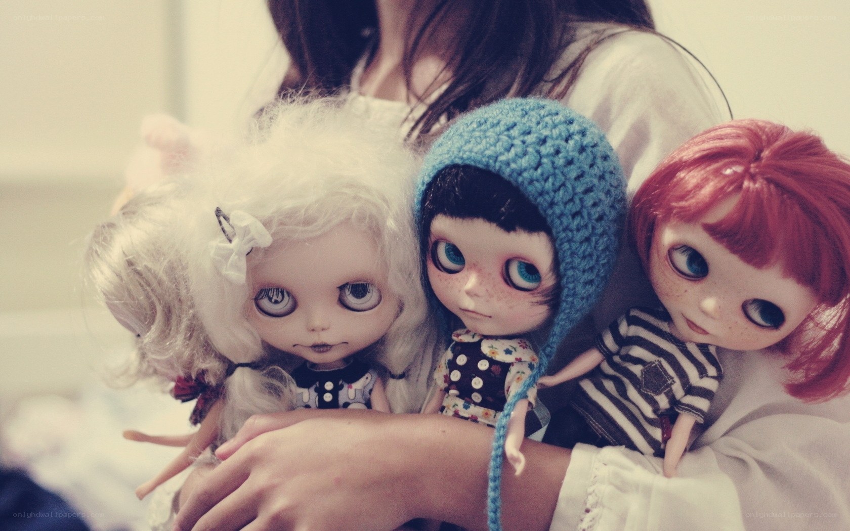 person holding three dolls