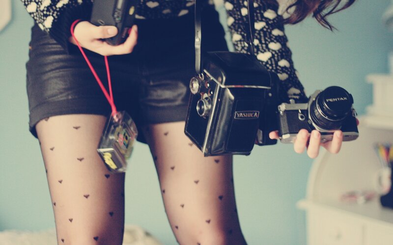 person holding vintage cameras