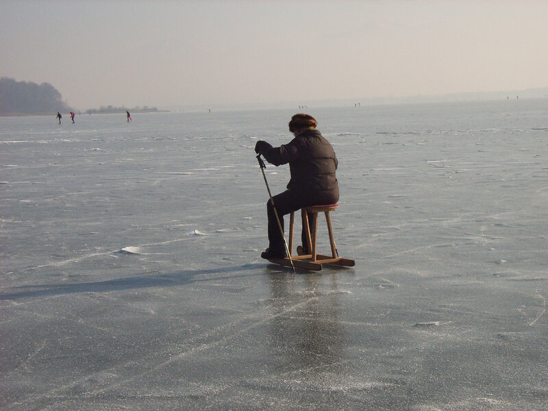 Person ice skating on frozen lake