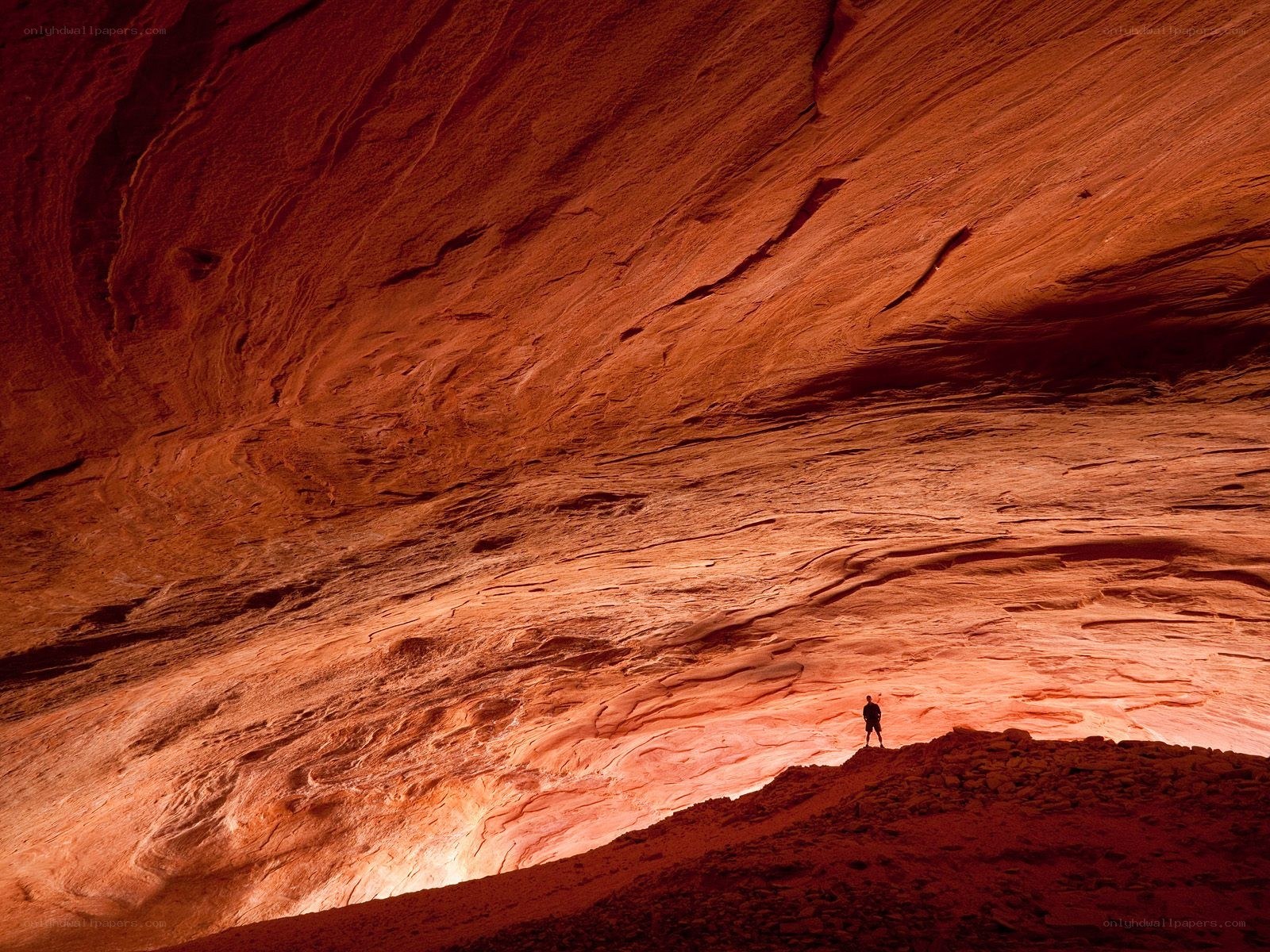 Person in a red rock cave