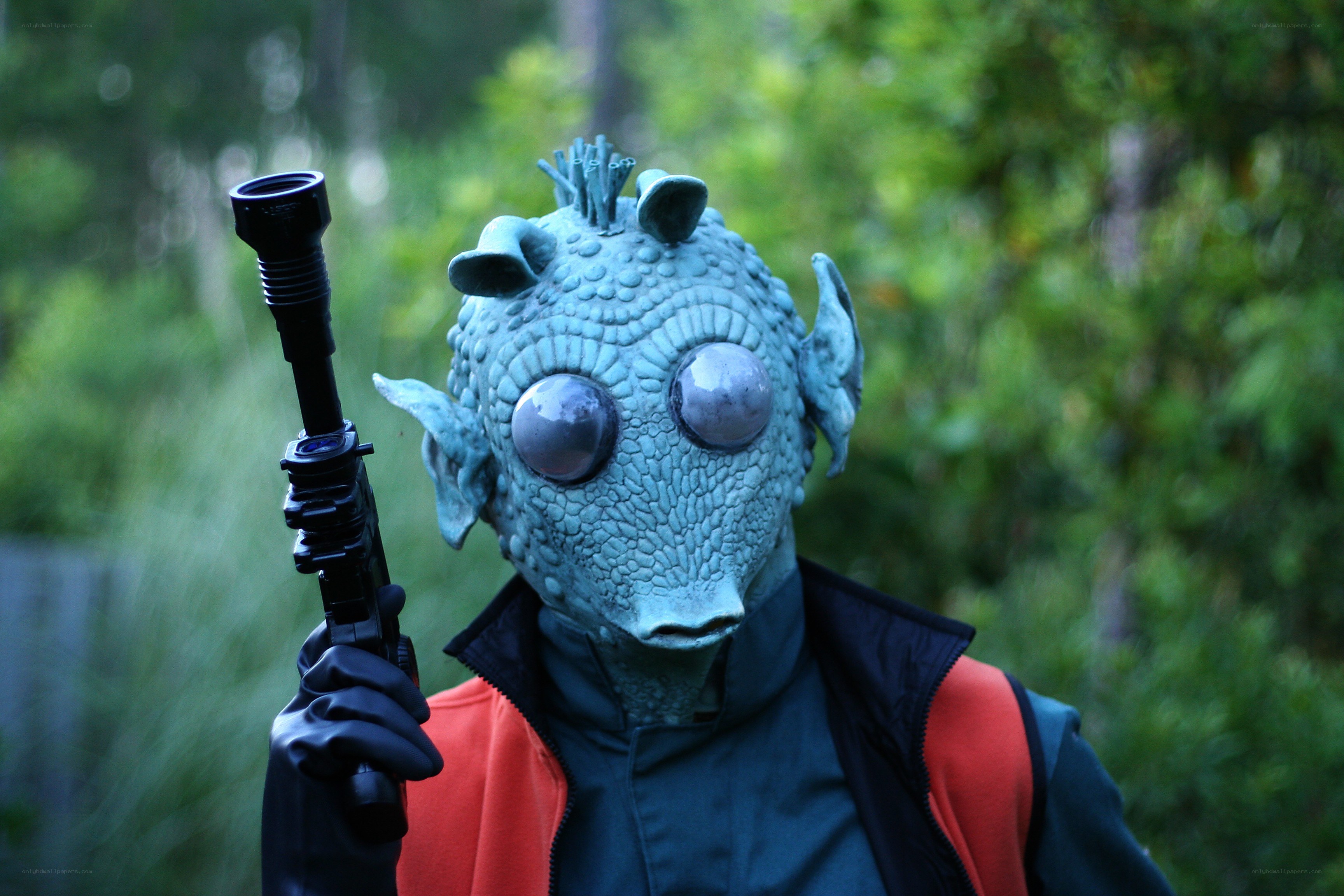 person in alien costume holding weapon
