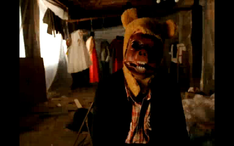 person in bear mask in cluttered room