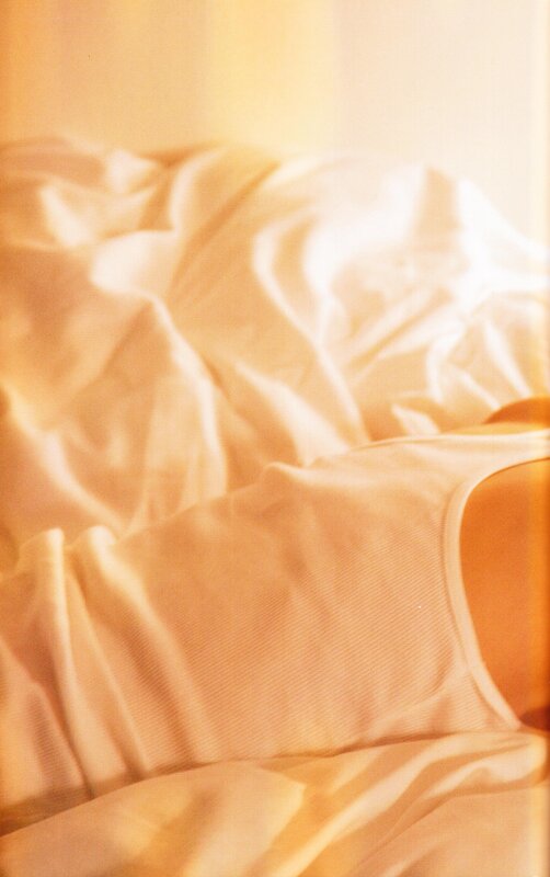 person in bed with white sheets