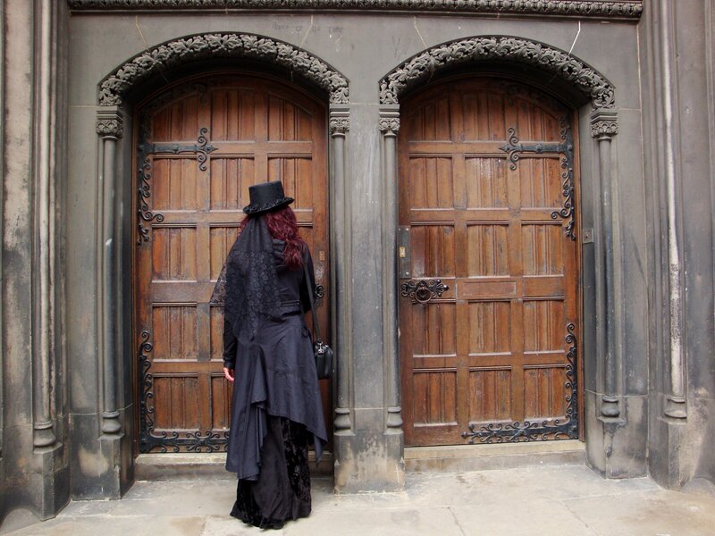 person in black at wooden doors