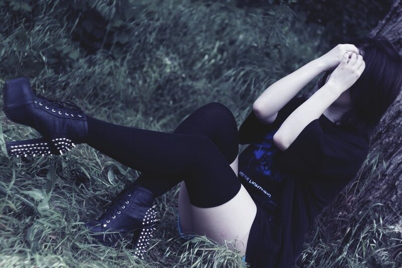person in black boots sitting on grass