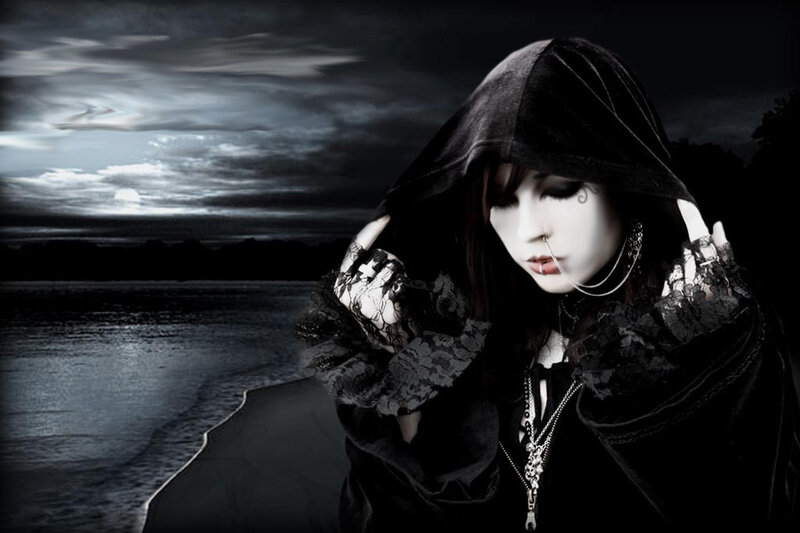 person in black hood by water
