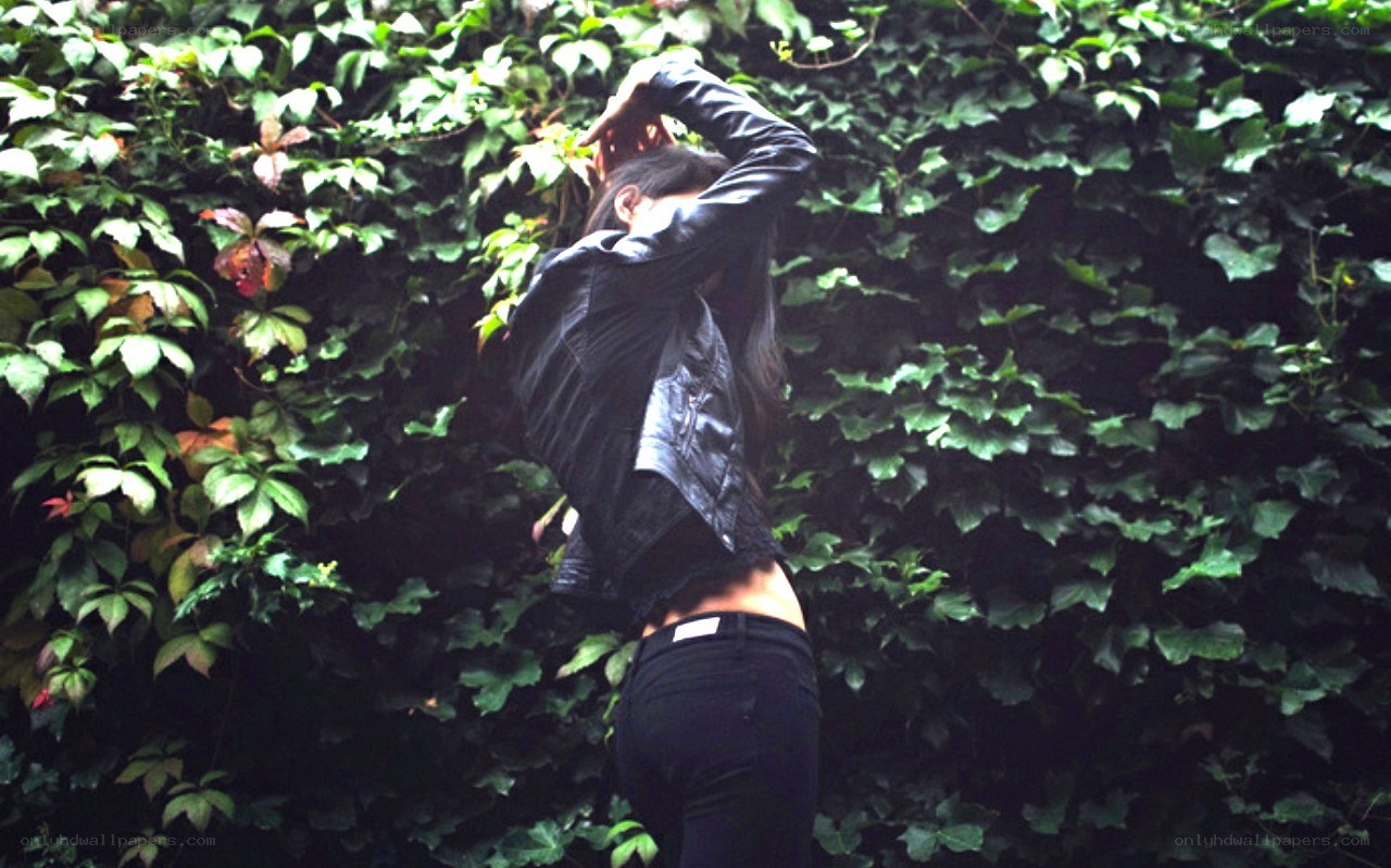 person in black jacket by ivy wall