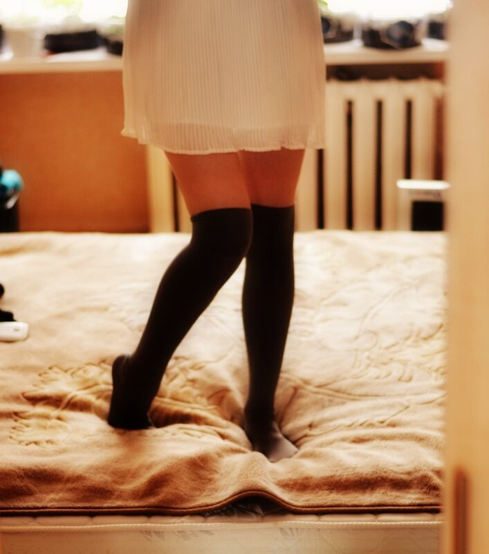 person in black socks standing on bed