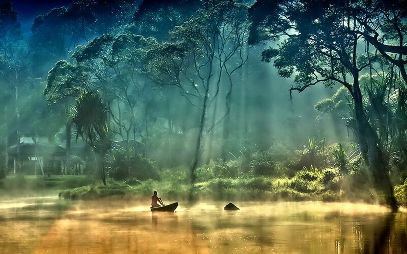 Person in boat on misty river