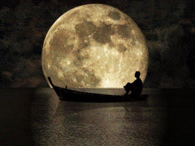 Person in boat under giant moon