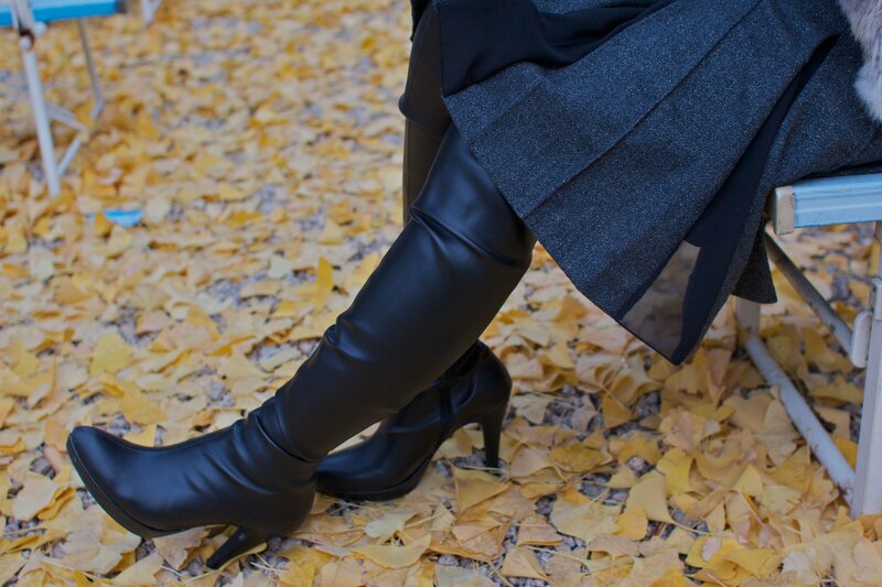 person in boots on autumn leaves
