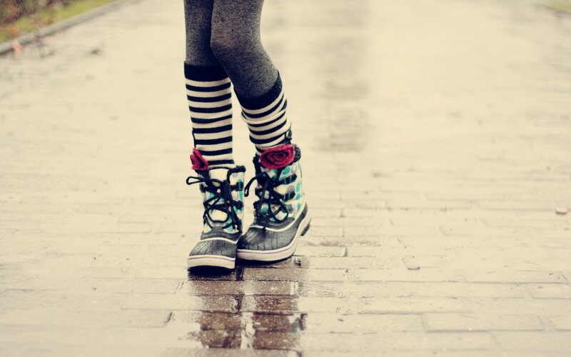 person in boots on wet pavement