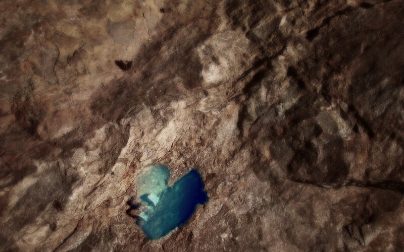 person in cave pool