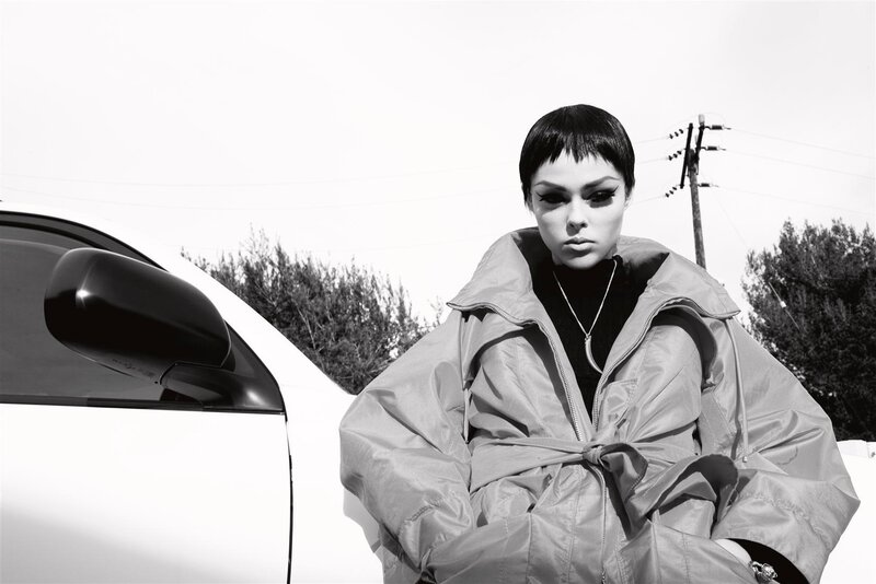 person in coat near car