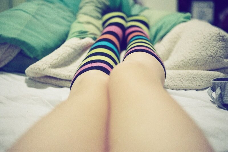 person in colorful socks on bed