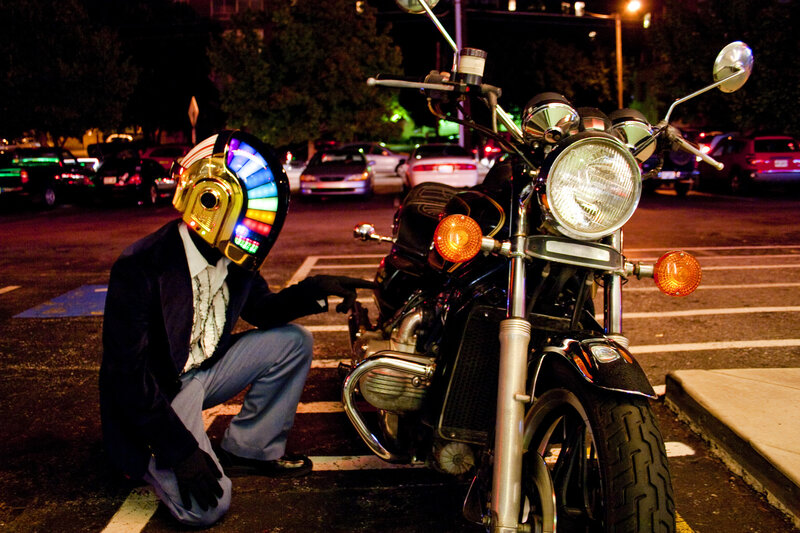 person in daft punk helmet with motorcycle