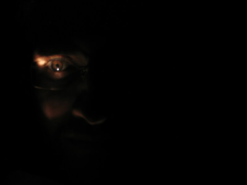 person in dark with glowing eye