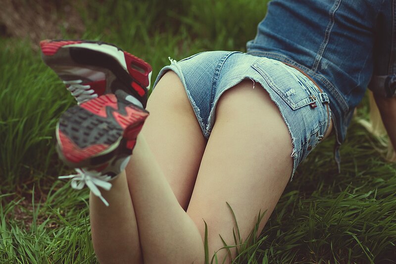 person in denim shorts on grass