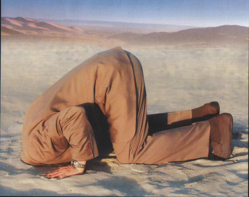 person in desert bowing