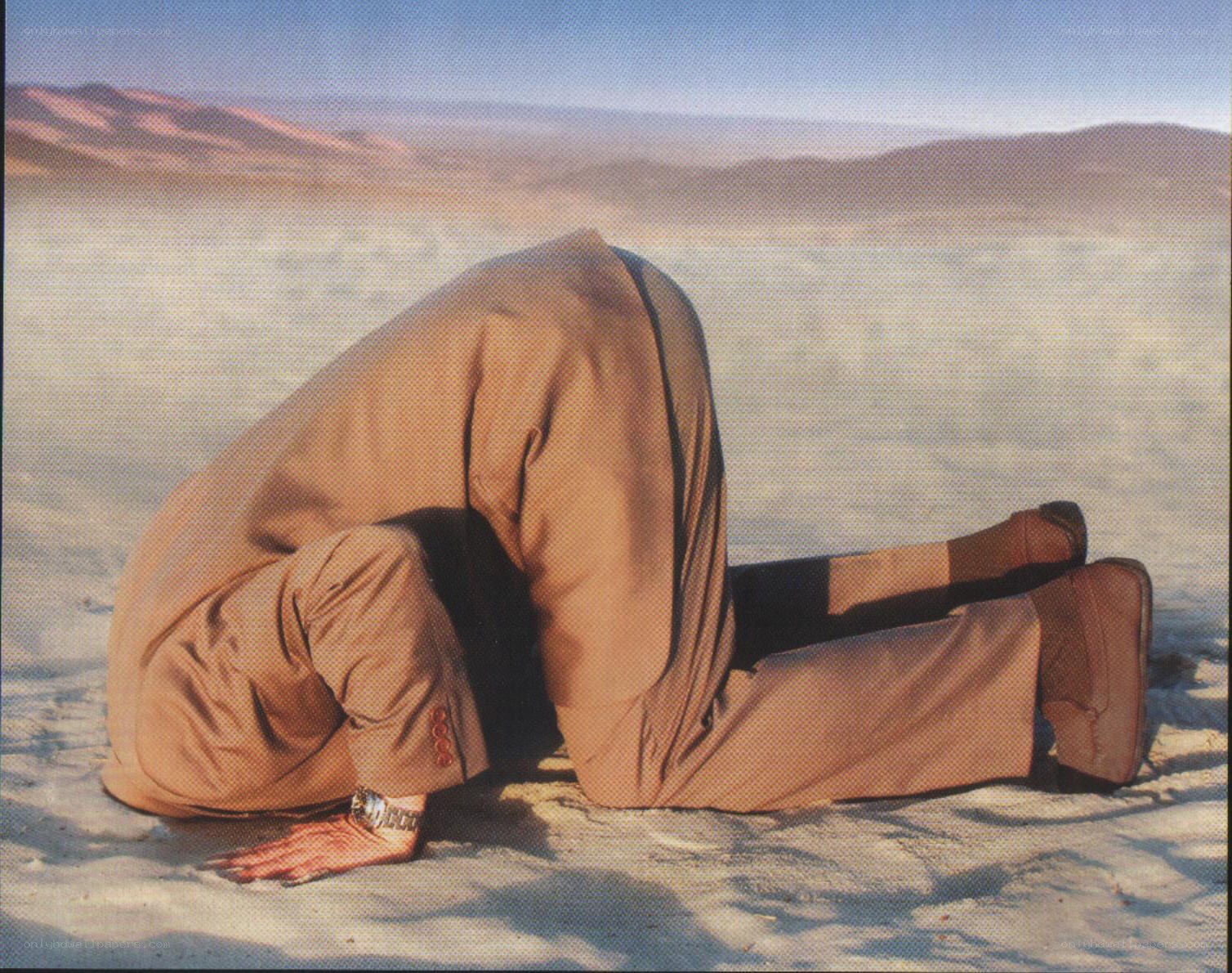 person in desert bowing