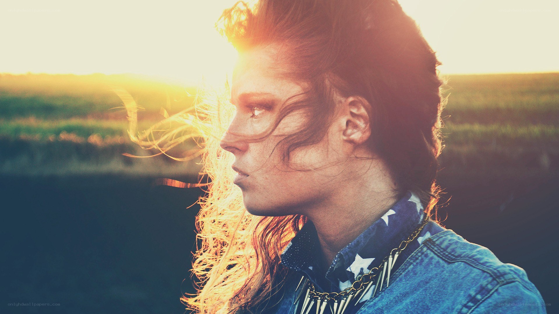person in field at sunset