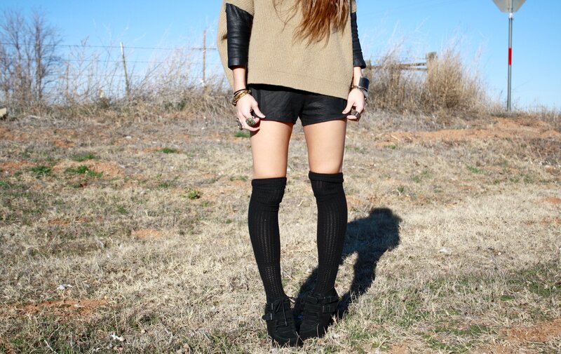 person in field wearing sweater and socks