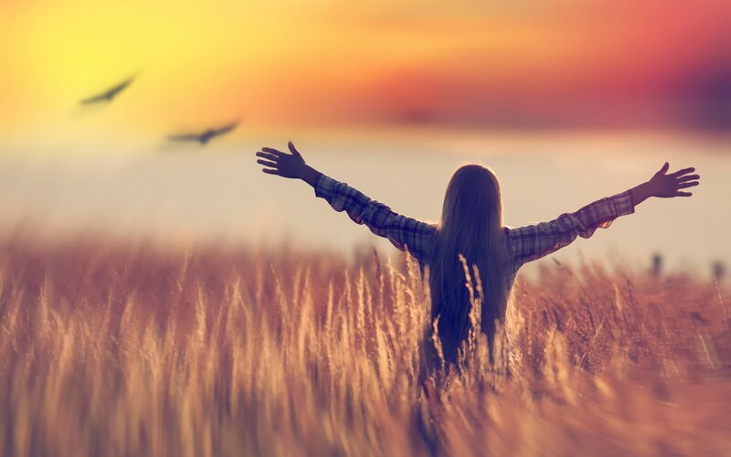 Person in Field with Arms Outstretched — Orange
