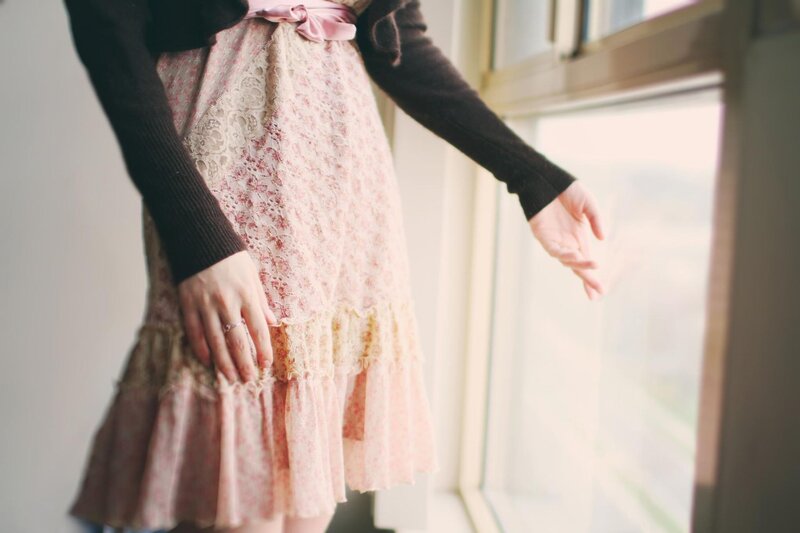 person in floral dress by window
