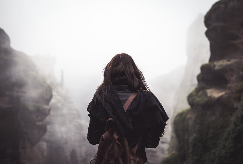 person in foggy canyon
