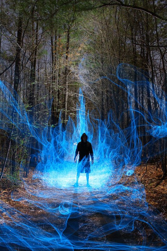 person in forest with blue light