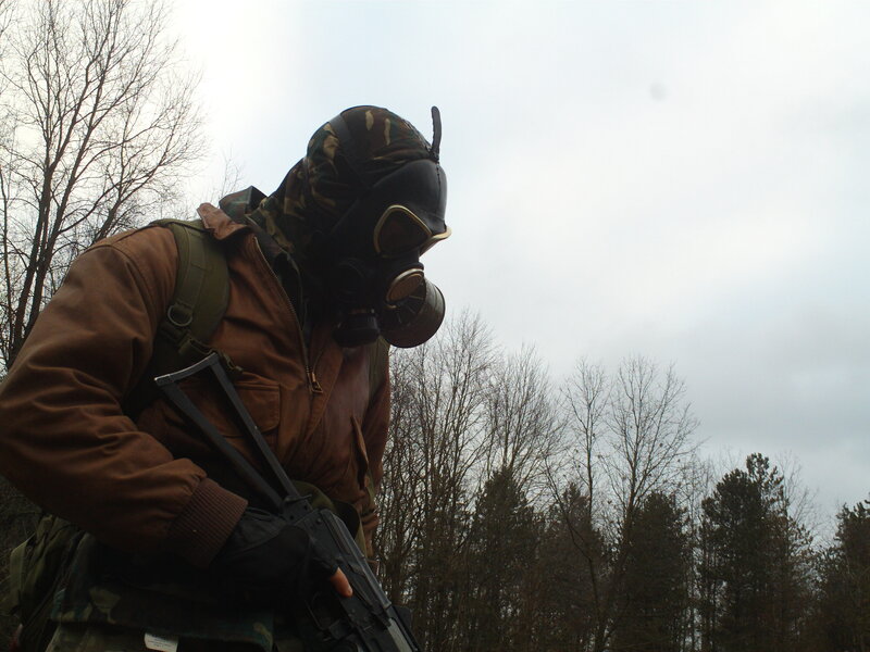 person in gas mask holding rifle