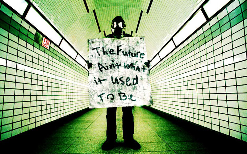 person in gas mask holding sign